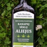 Ekologiškas Pluoštinių kanaių aliejus buteliuke, ant žolės
